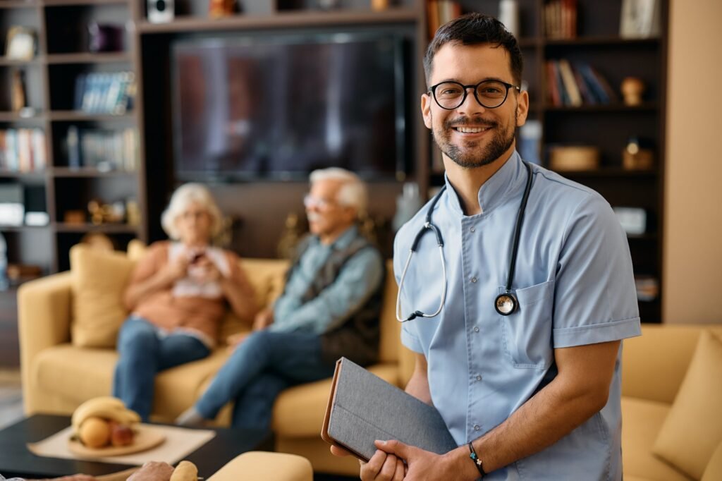 Happy male nurse at residential care home looking at camera.