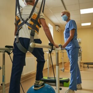 Mature man walking in parallel bars at rehabilitation room